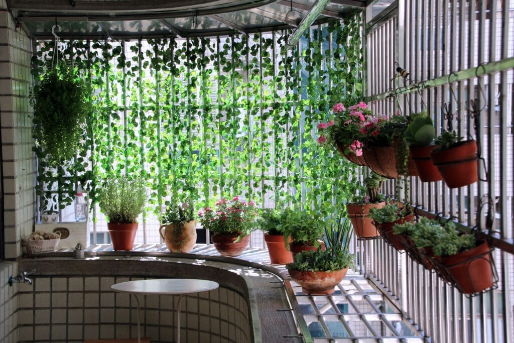 Cozy balcony decorated with hanging and potted plants, ideal for relaxation.